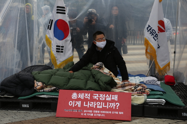 황교안 자유한국당 대표가 24일 청와대 분수대 앞에서 단식 농성 중 잠시 자리에 앉아 한국당 의원들을 쳐다보고 있다. ⓒ정아인 기자